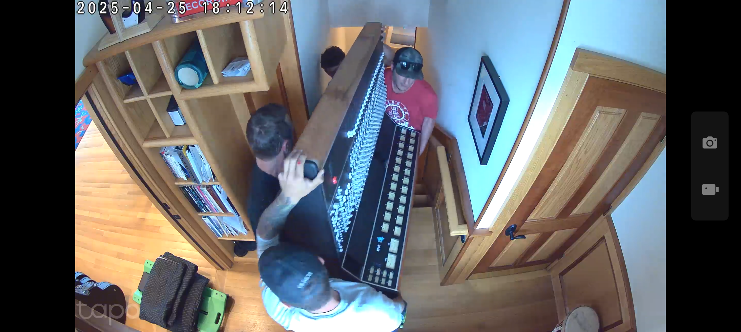 Four people moving an API 2448 mixing console up a staircase to the studio