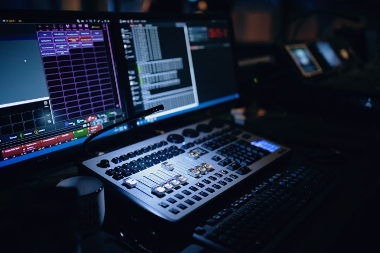 Music production workstation with computer display and studio equipment